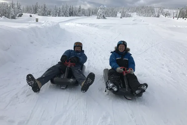 To personer sitter på kjelke