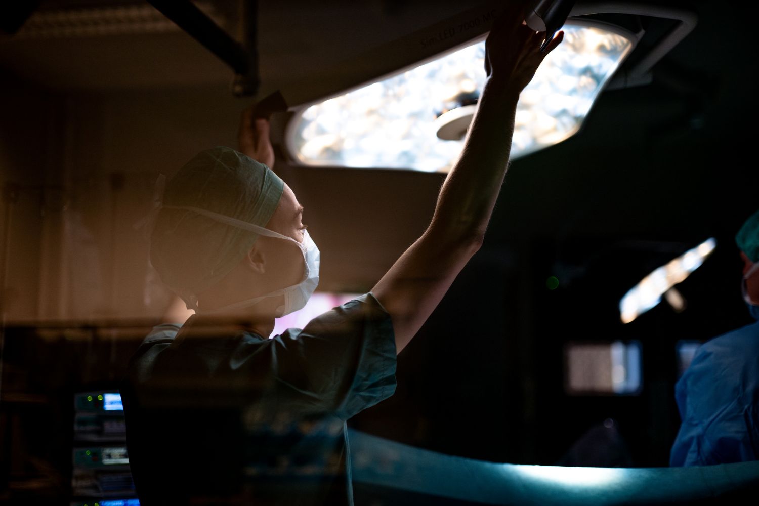 Operasjonssykepleier strekker seg mot operasjonslampe