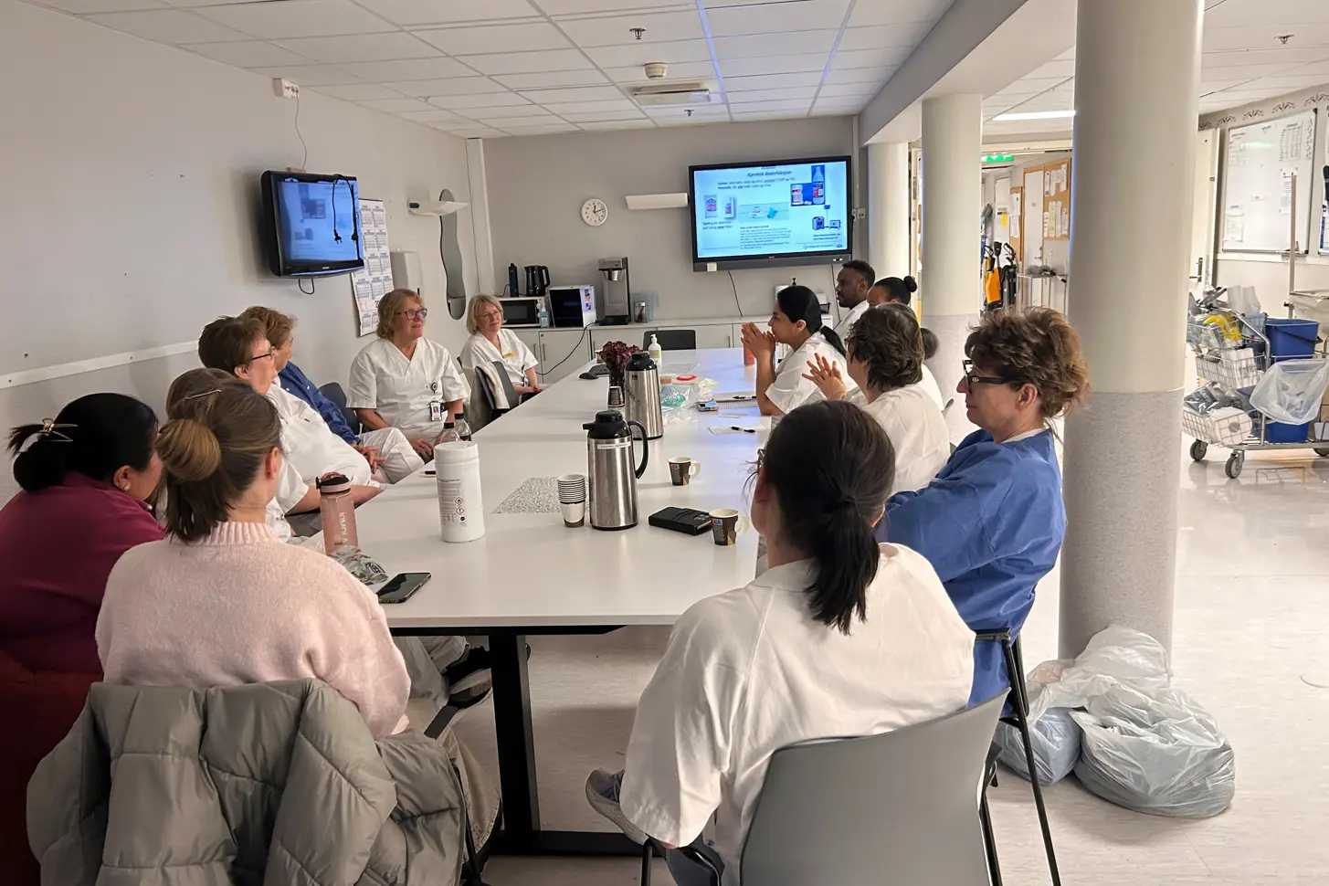 En gruppe mennesker som sitter rundt et bord og ser på en presentasjon