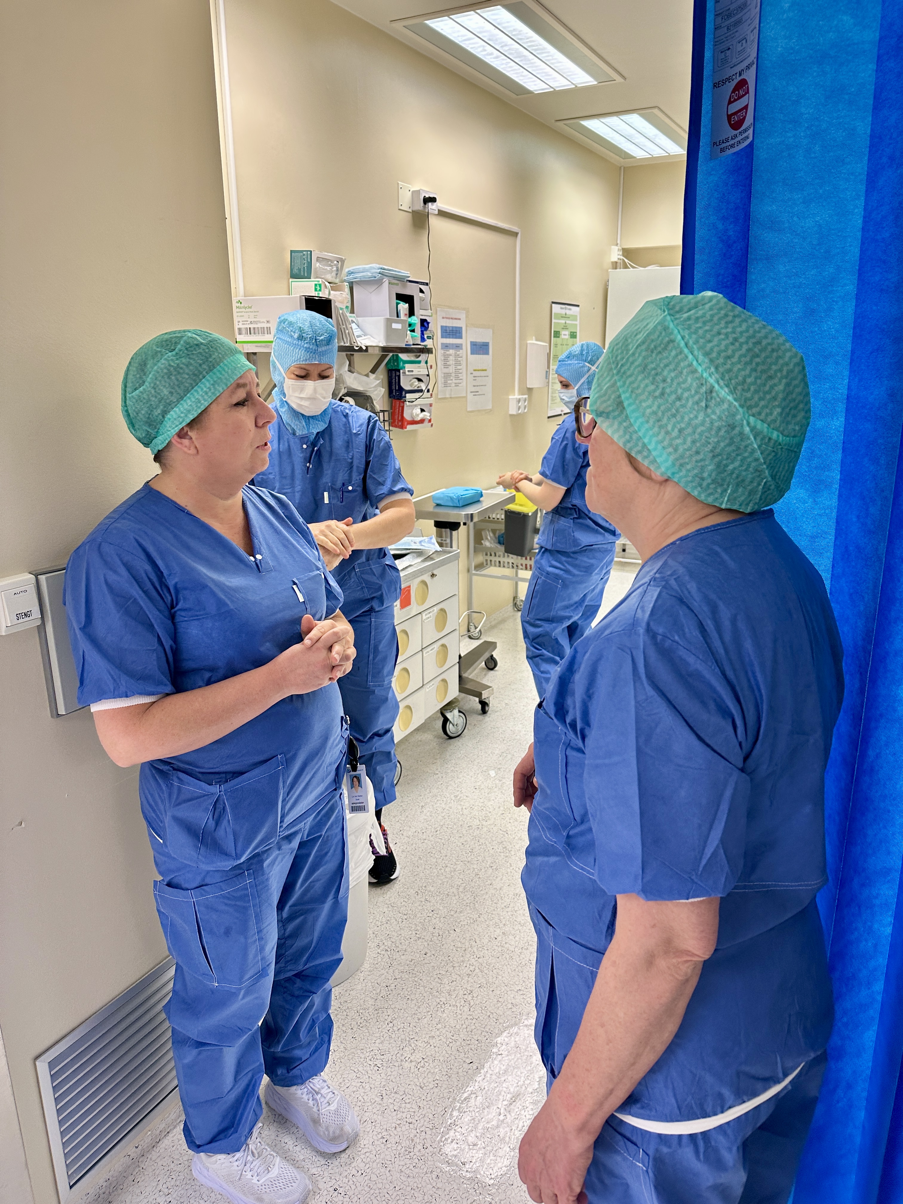 En gruppe mennesker i kirurgiske skrubb i et rom