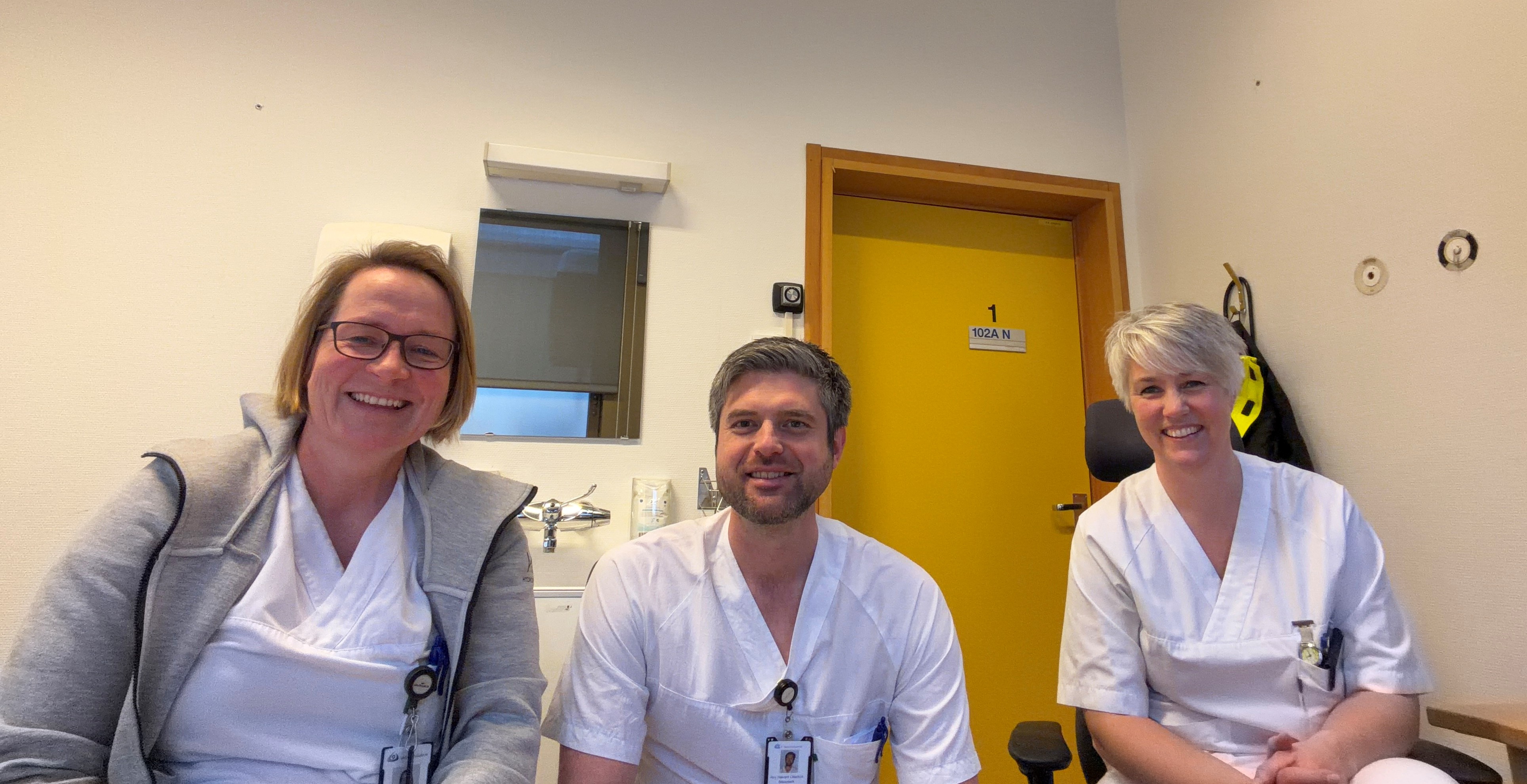 Tre ansatte i hvit uniform, gruppebilde