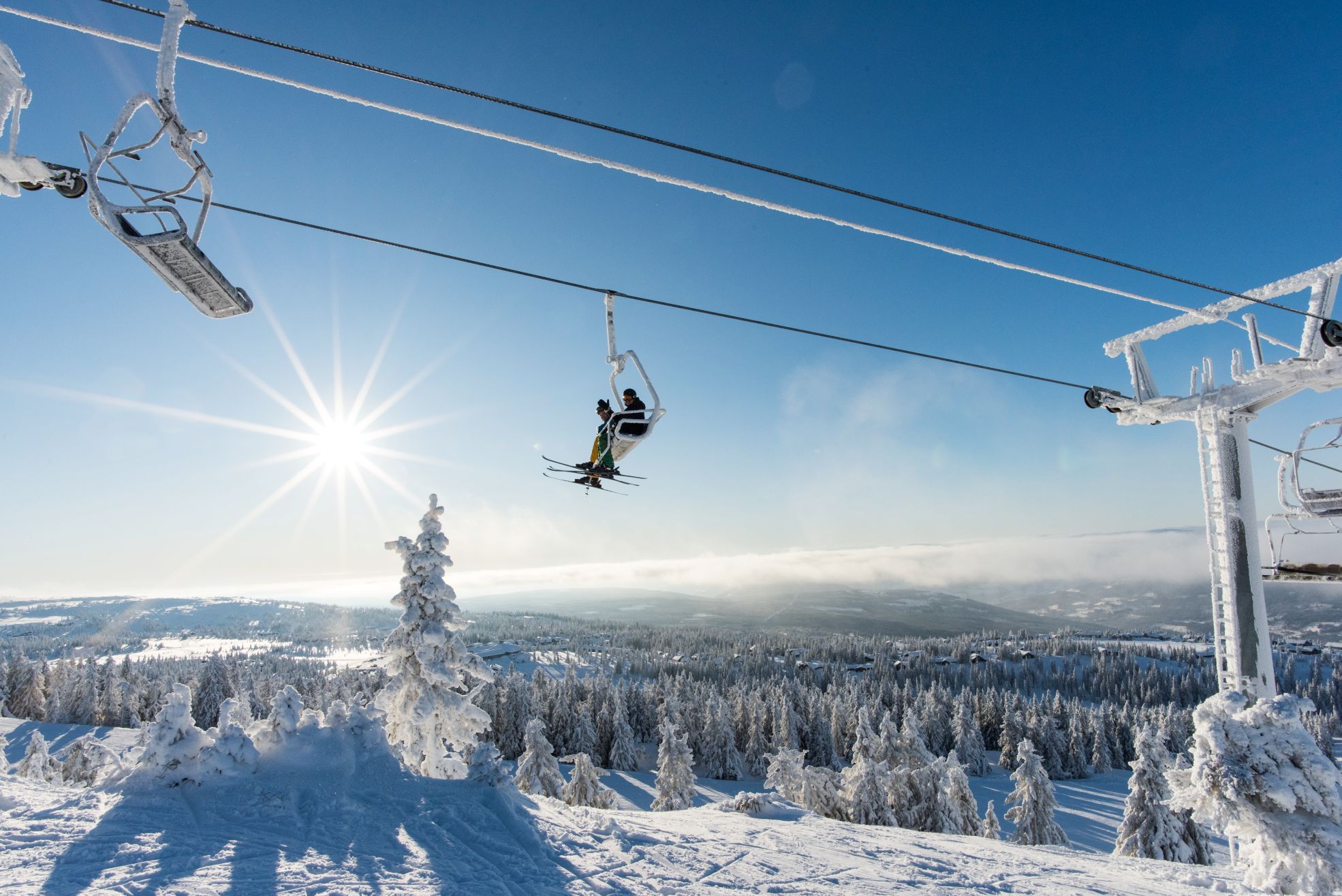 Alpintbakke med skiheis og vinterlandskap.