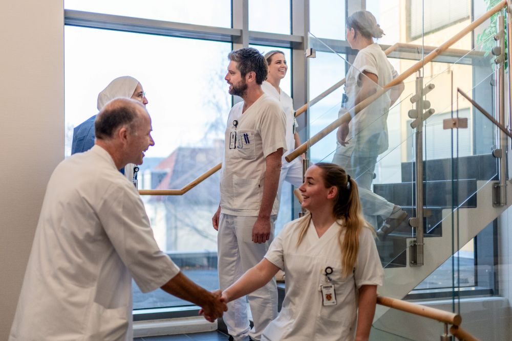 A group of people in white lab coats shaking hands