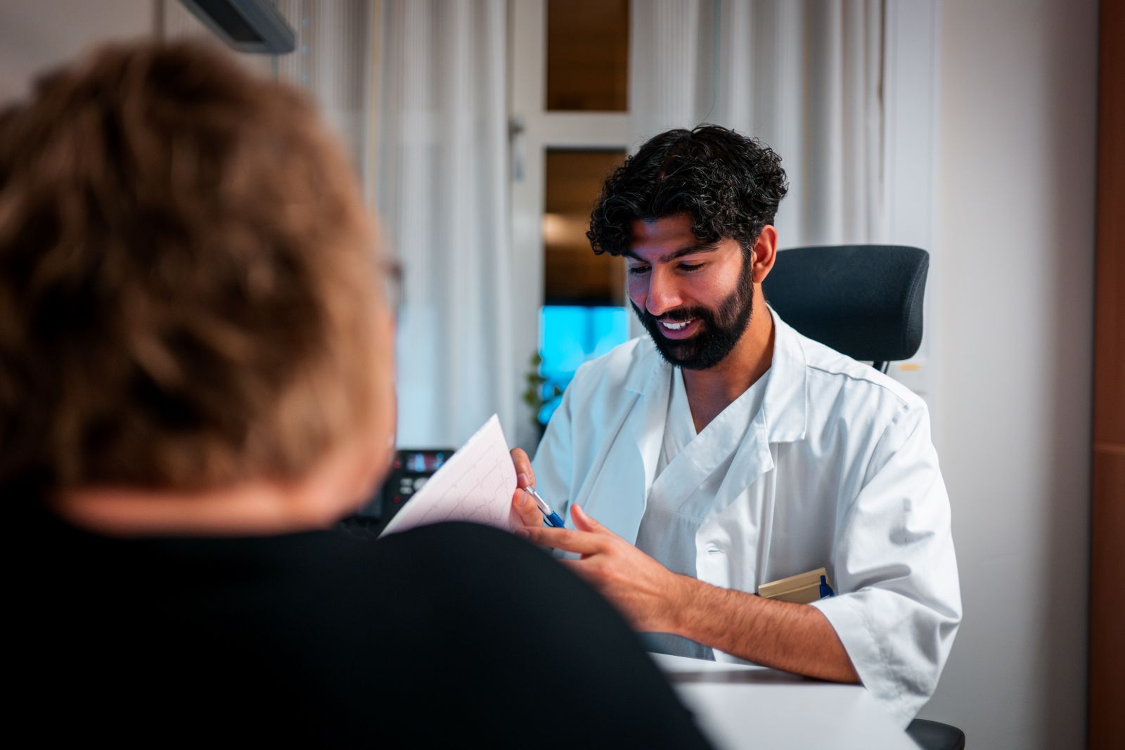 Lege i dialog med pasient.