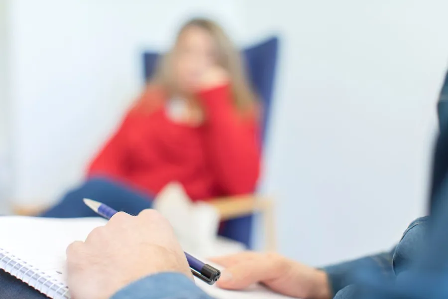 Illustrasjon: To personer i samtale, i hver sin stol. Bilde har filter for ikke å identifisere personen.