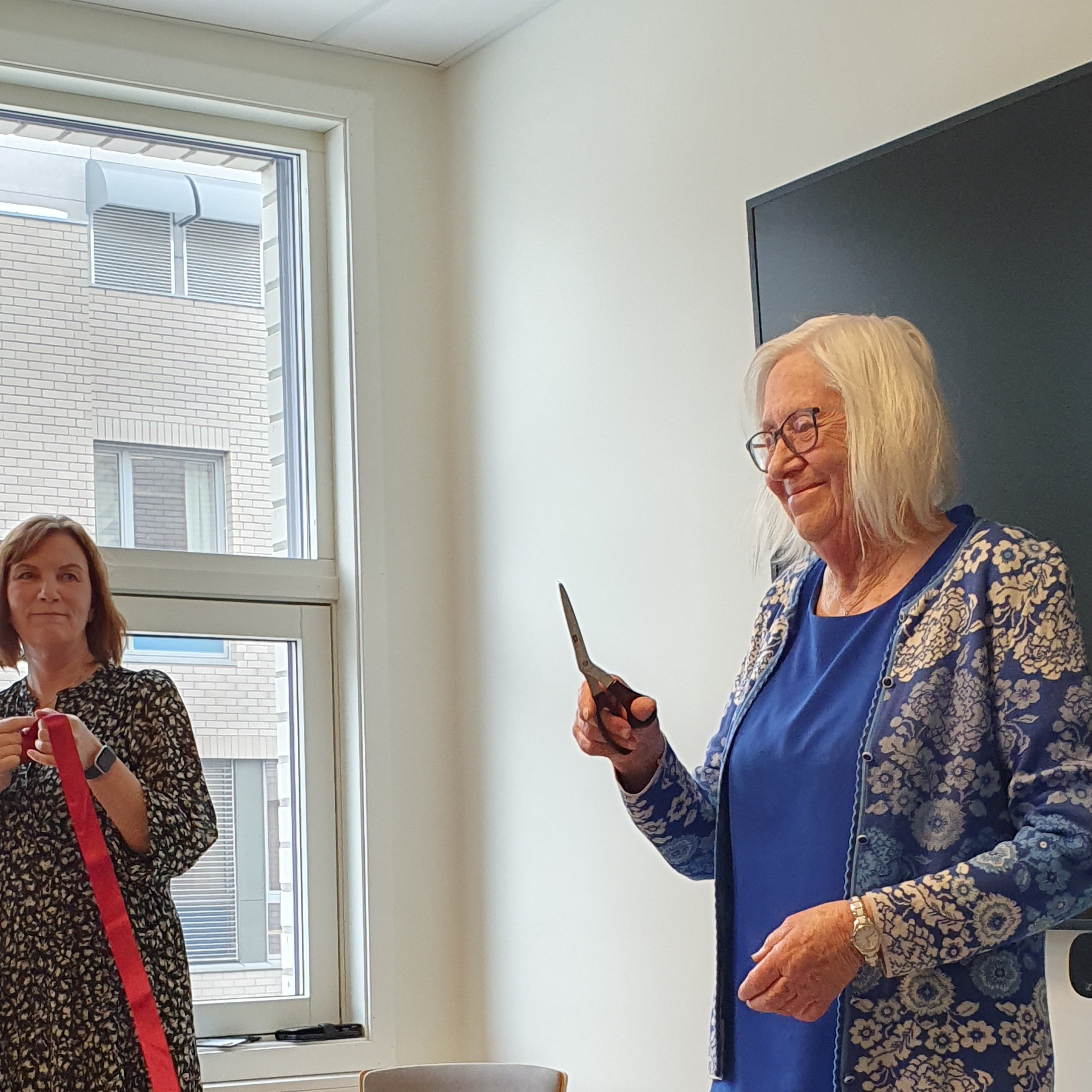 En person som holder en penn og en person som står ved et vindu