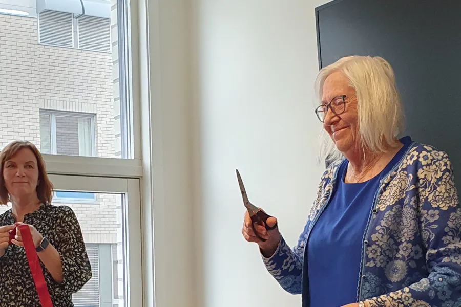 En person som holder en penn og en person som står ved et vindu