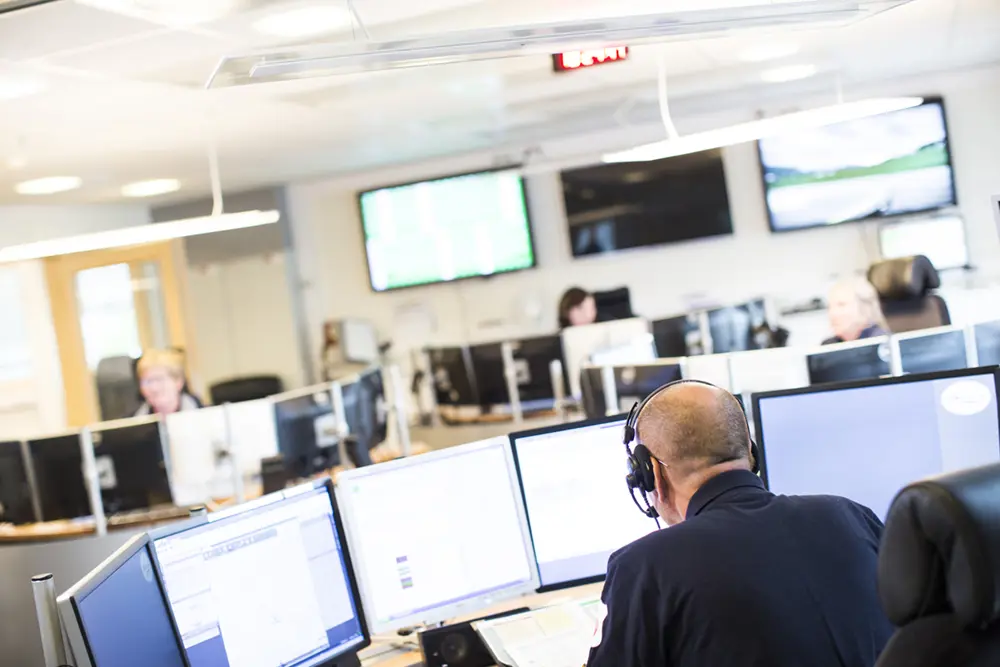 En gruppe mennesker i et rom med datamaskiner