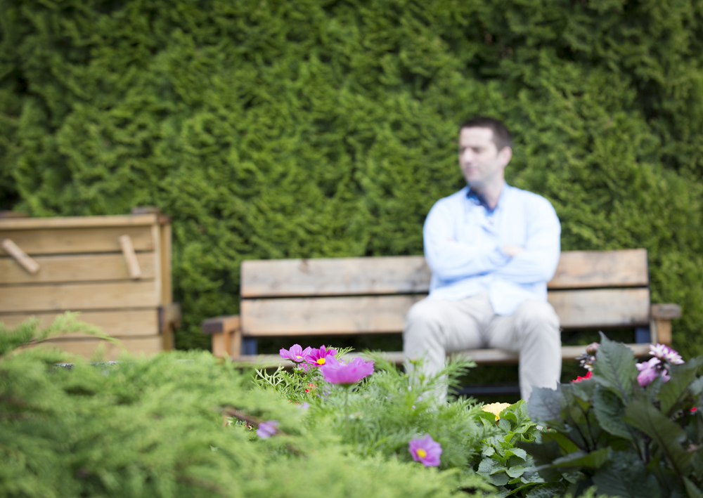 Pasient sitter på en benk utendørs