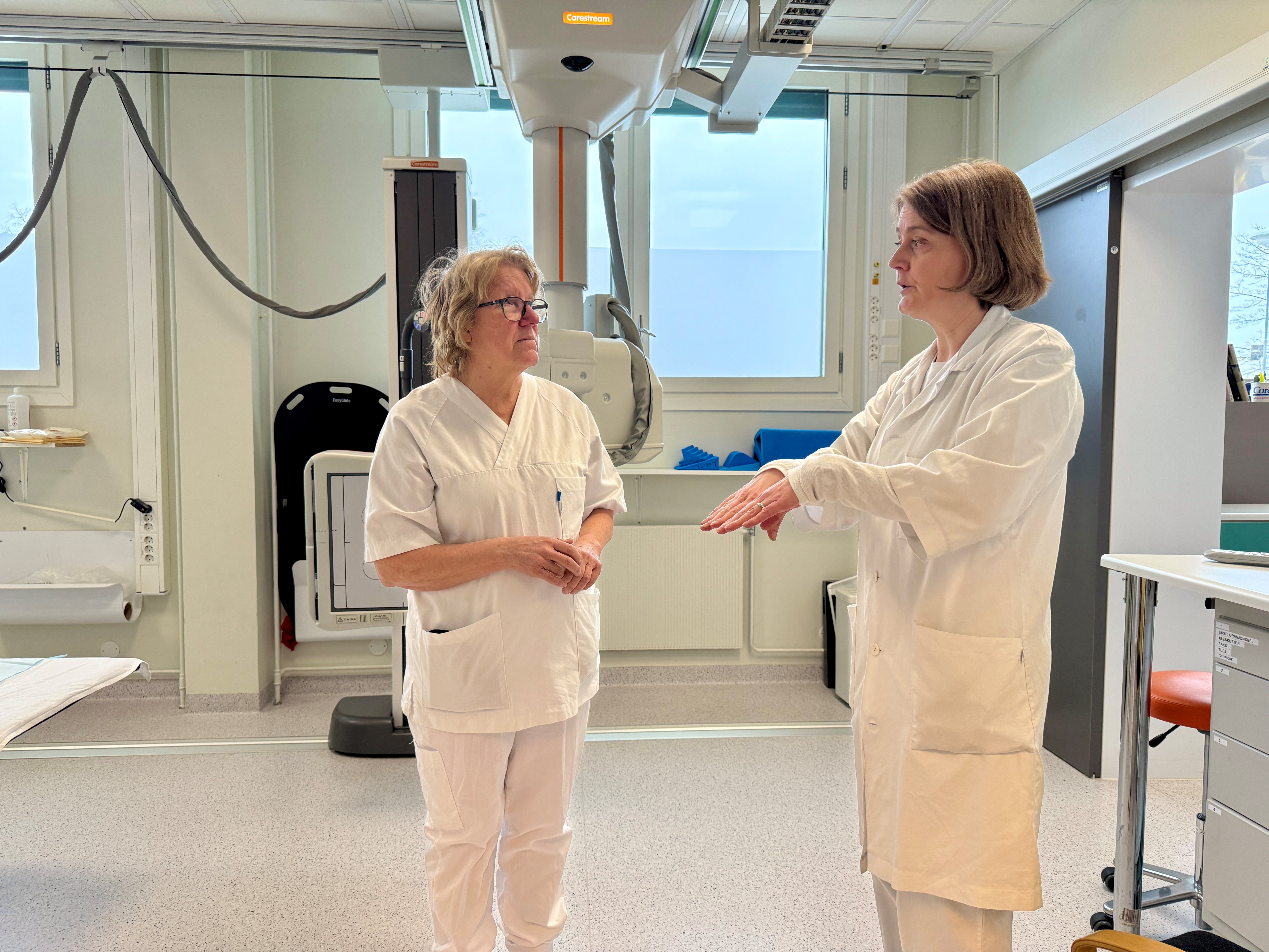 Kvinner i hvite laboratoriefrakker som snakker