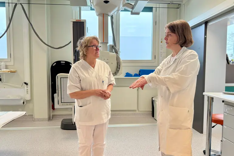 Kvinner i hvite laboratoriefrakker som snakker