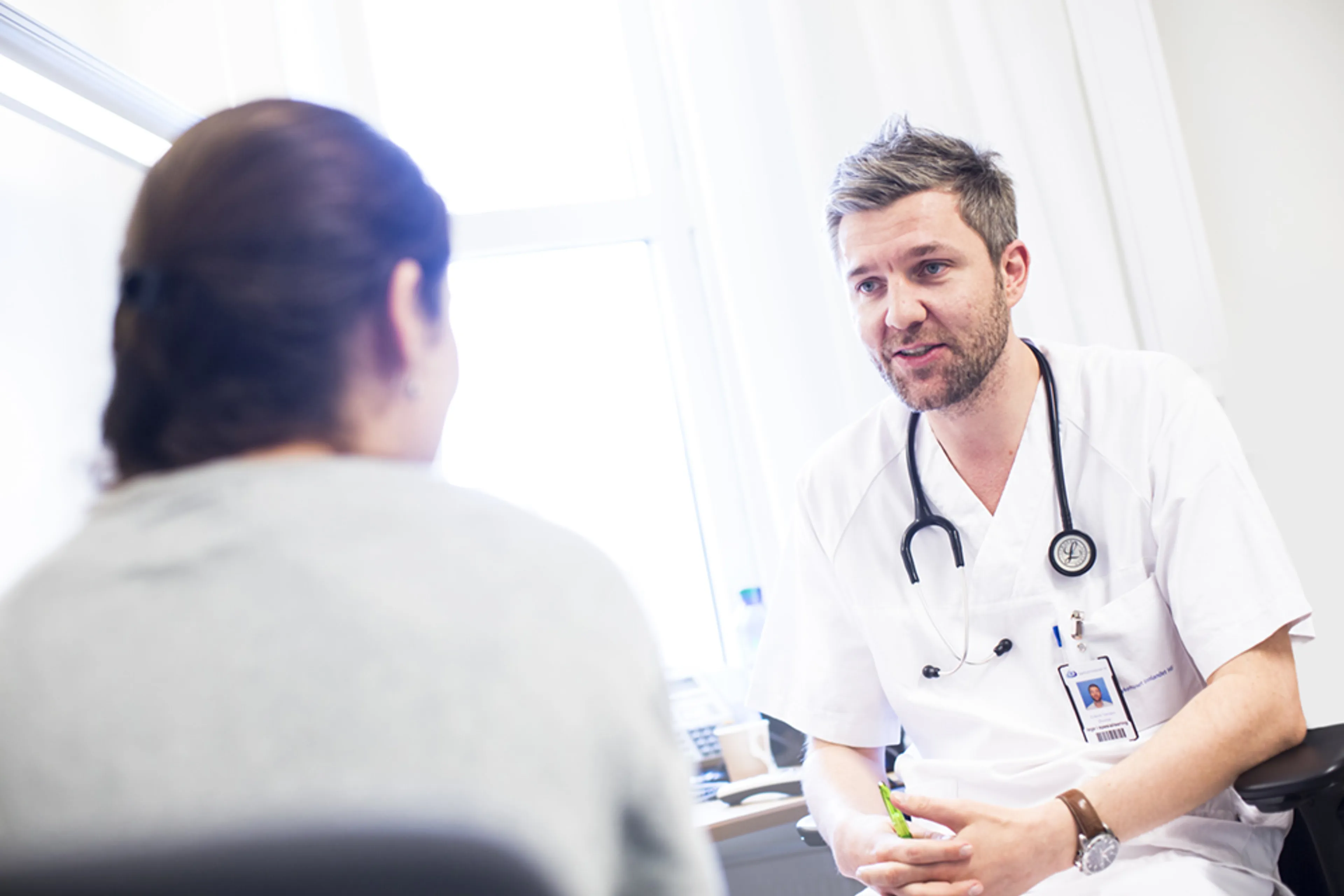 En lege som snakker med en pasient