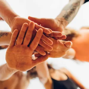 En gruppe mennesker som holder hendene nært hverandre