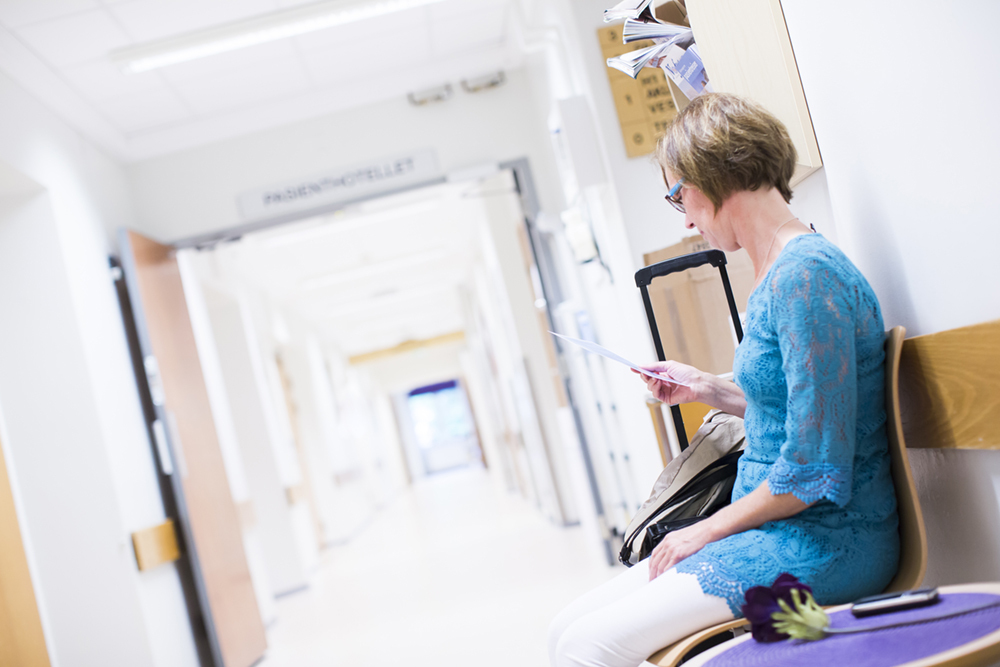 En person som sitter i en stol i sykehusgang