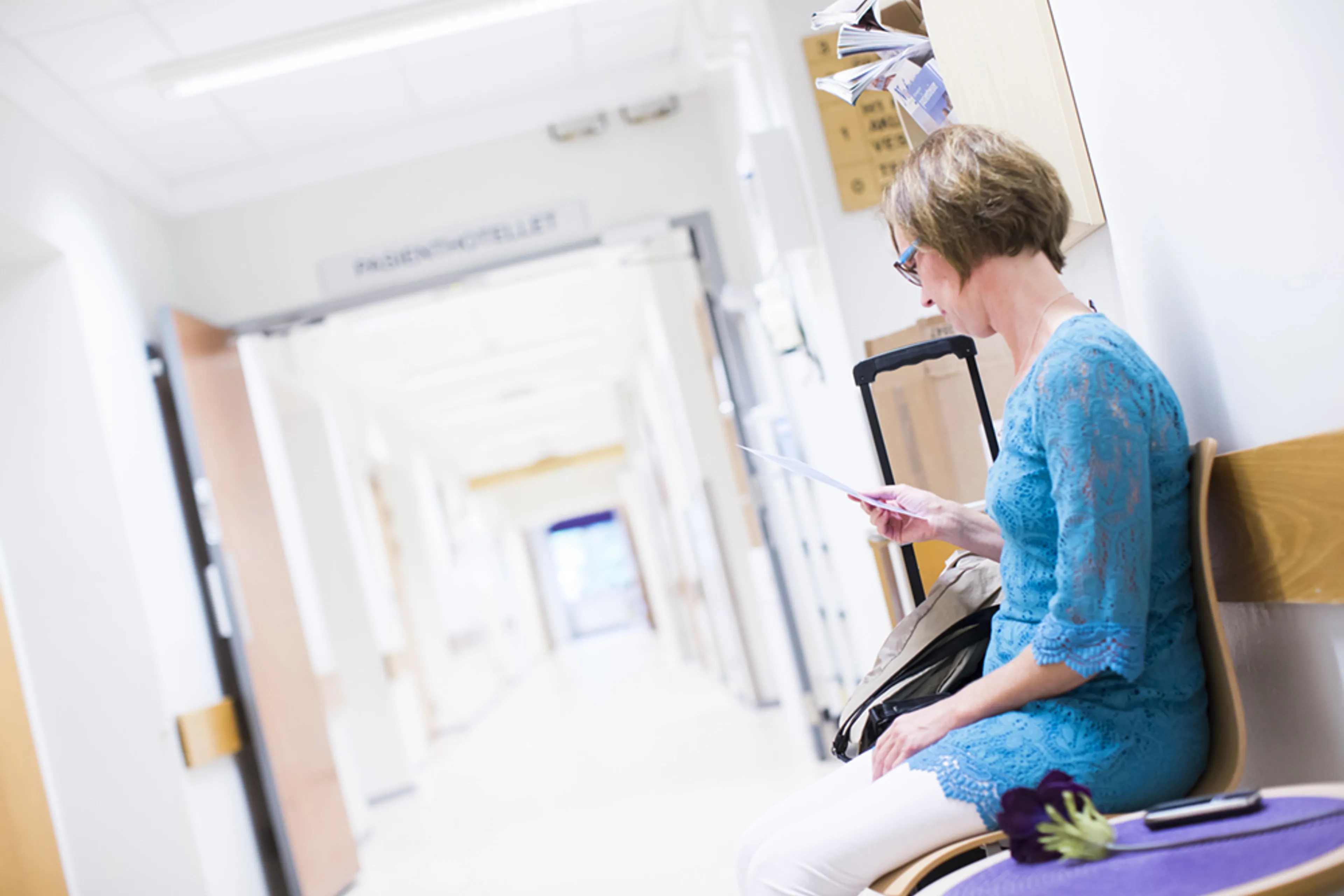 En person som sitter i en stol i sykehusgang