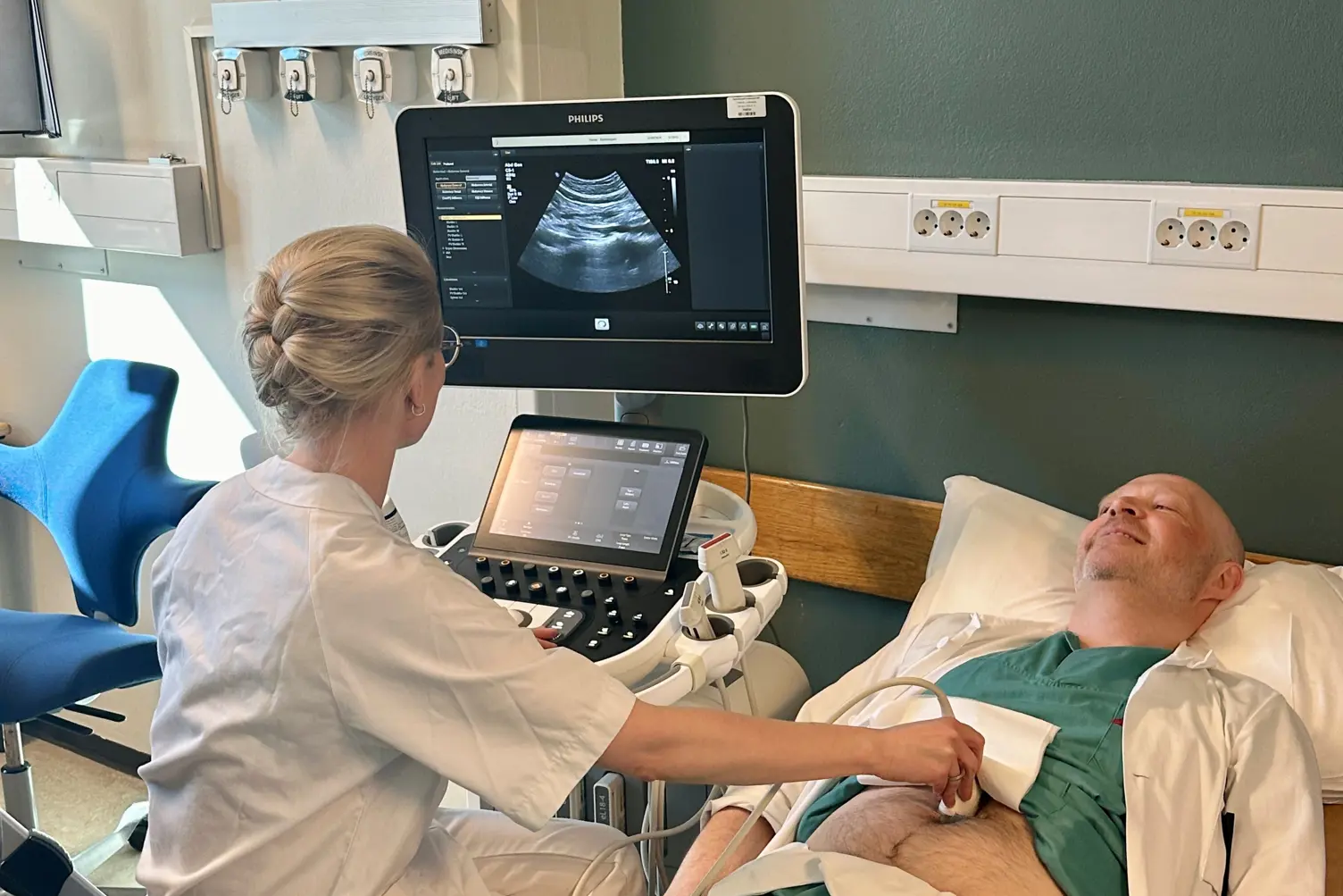 Lege tar ultralyd av aorta hos pasient.