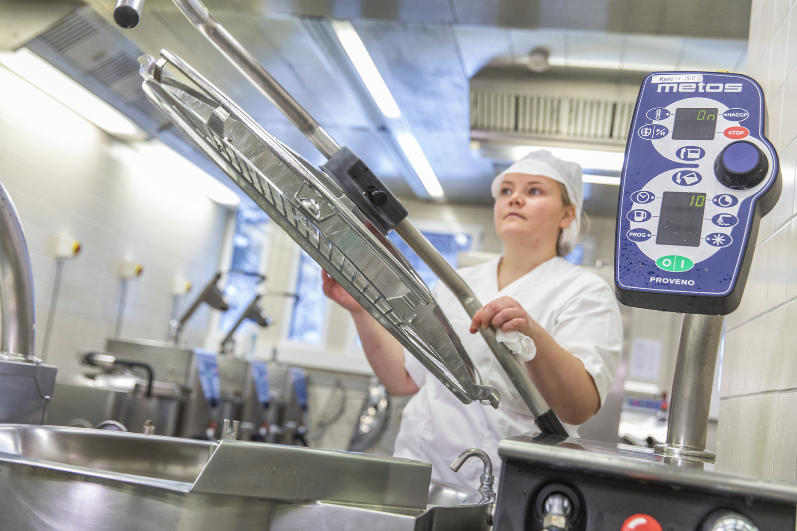 A person in a white chef outfit working in a kitchen