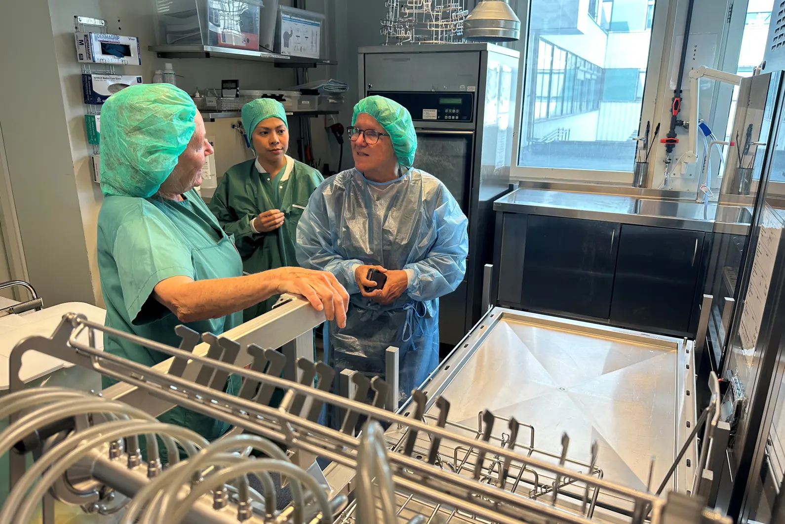 En gruppe mennesker i kirurgiske skrubb som jobber i et rom