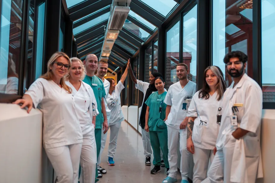 En gruppe helsepersonell poserer i sykehuskorridor