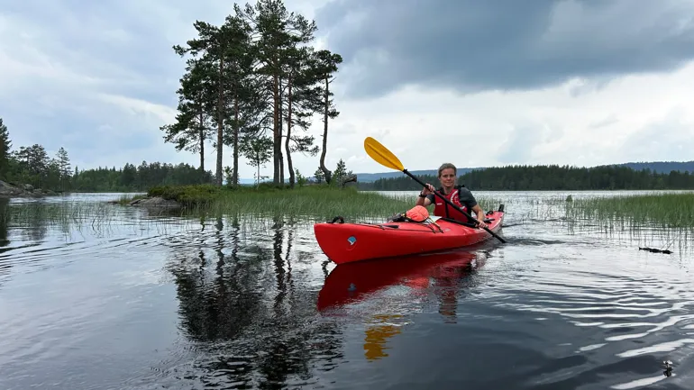 En kvinne i kano på en innsjø
