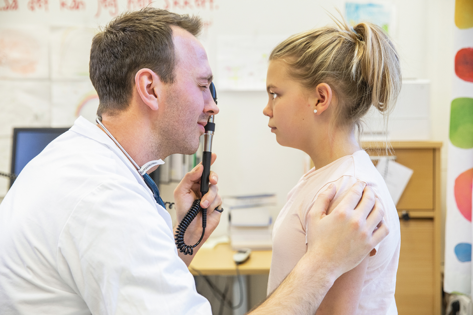 Lege undersøker øynene til et barn.