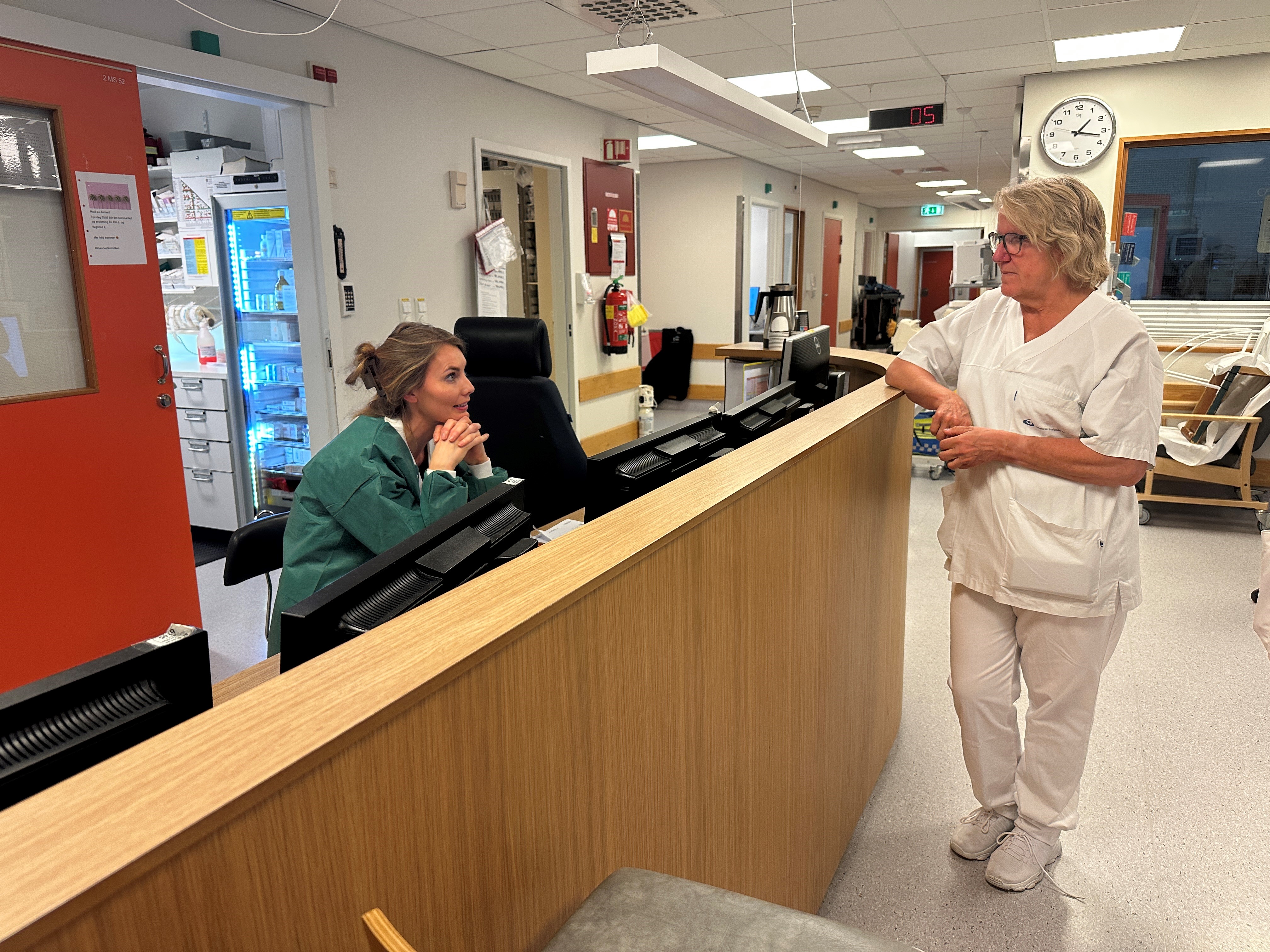 En kvinne som snakker med en mann ved et skrivebord