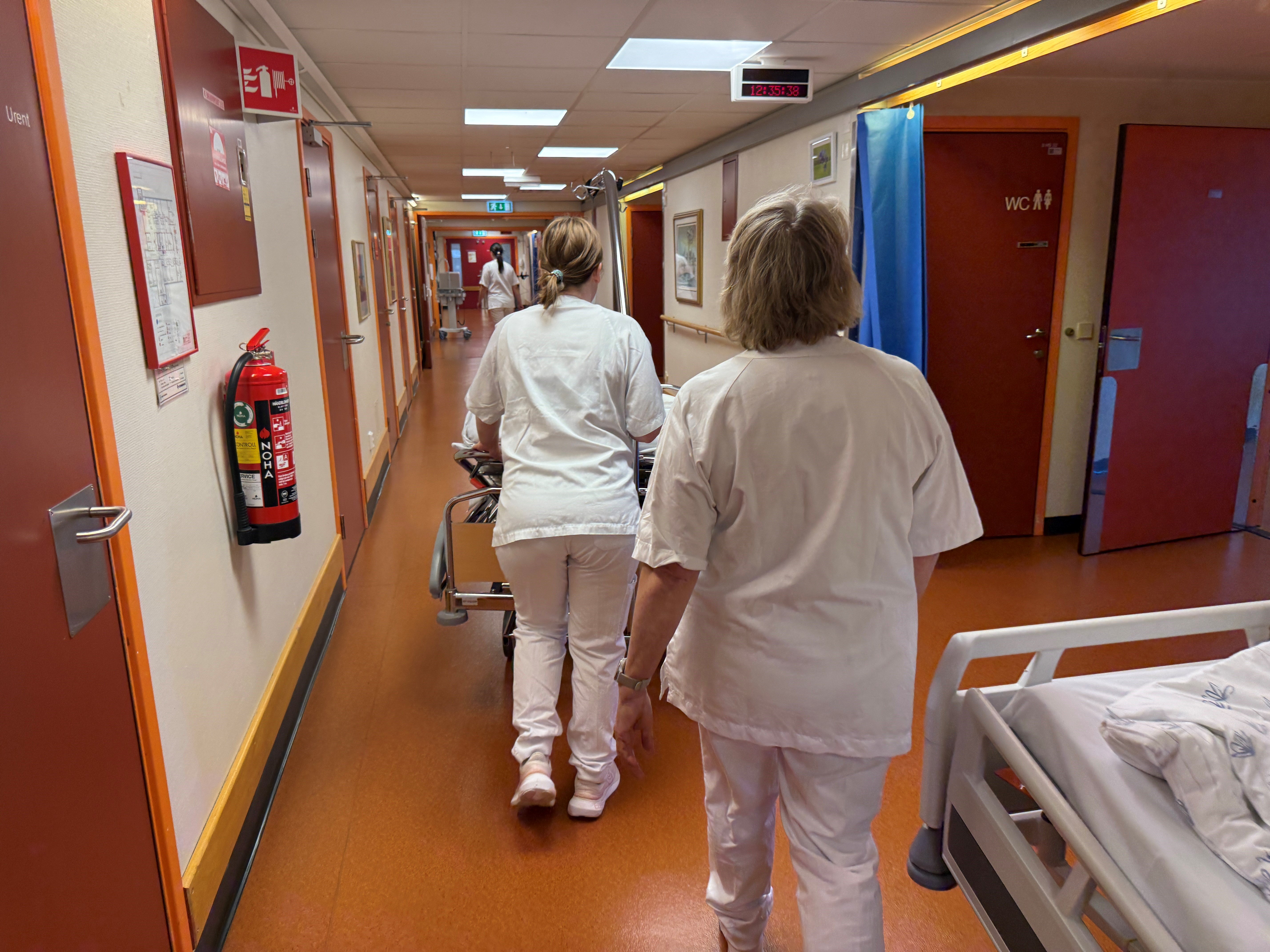 Portør og hospitant med seng i korridor