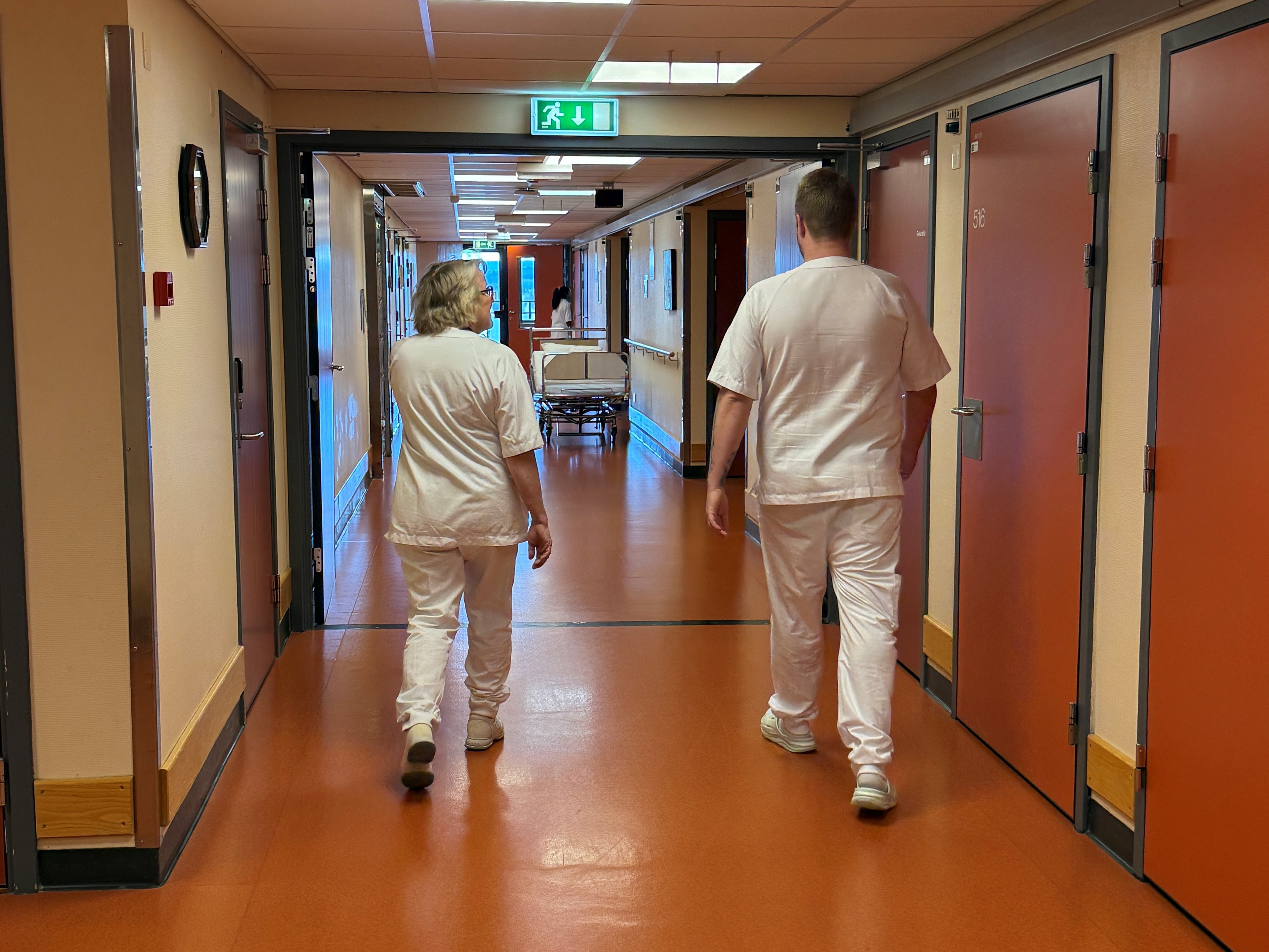 Et par personer som går nedover en korridor