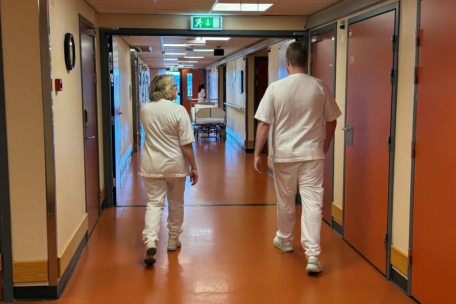 Et par personer som går nedover en korridor