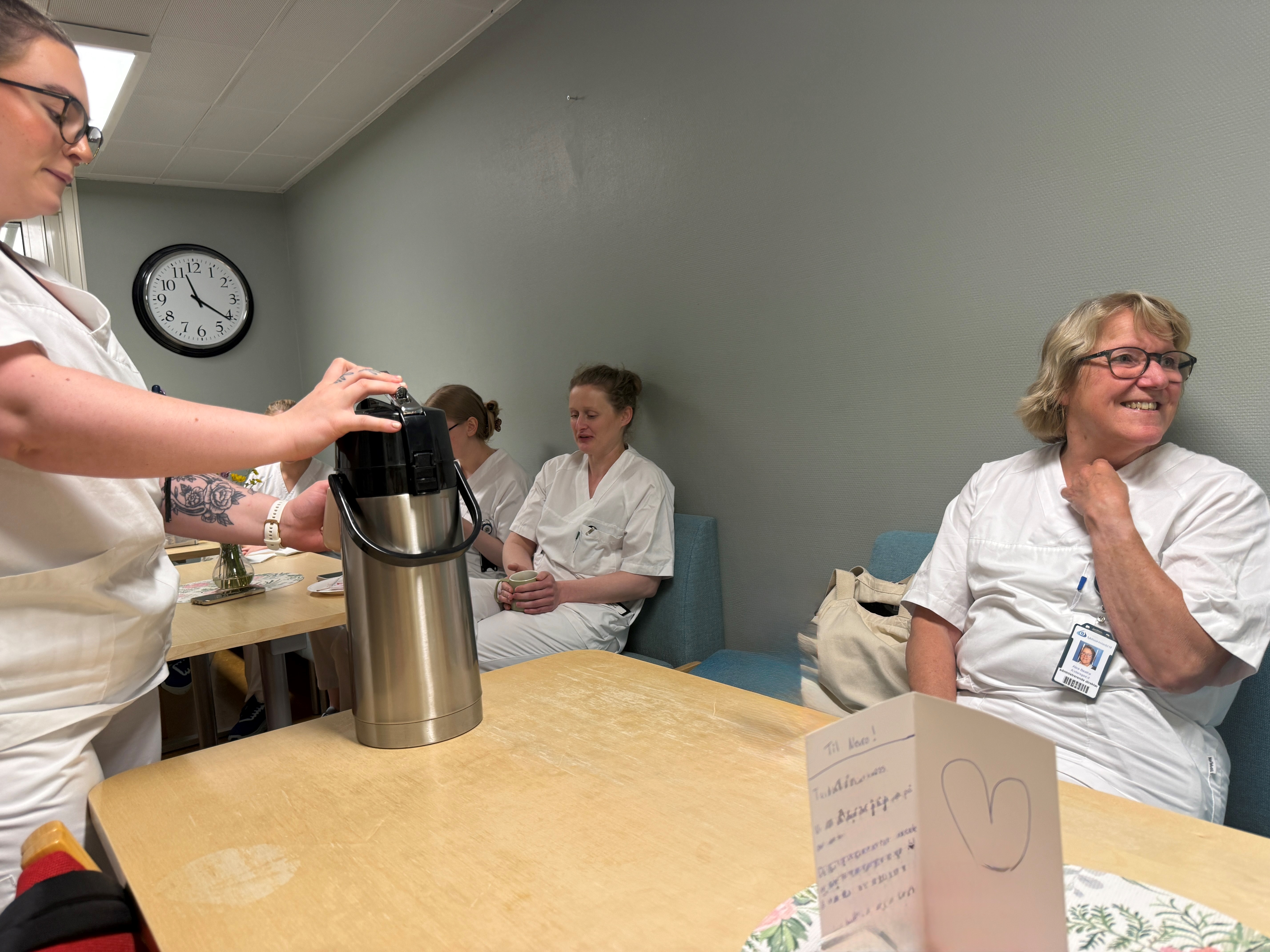 En person som tar bilde av en person som sitter ved et bord