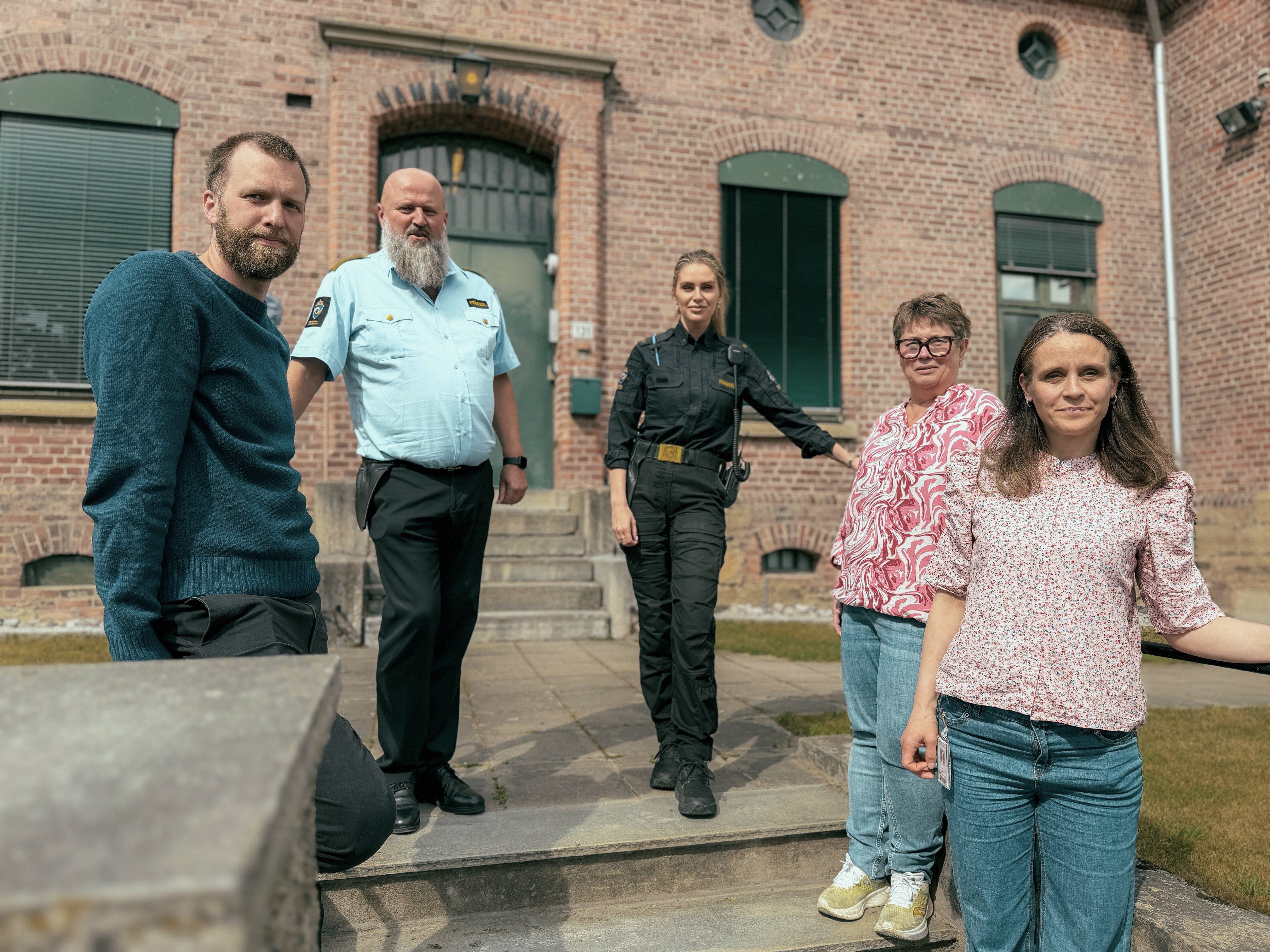 Sykeuhsterapeuter og fengselsansatte foran fengslet, gruppebilde