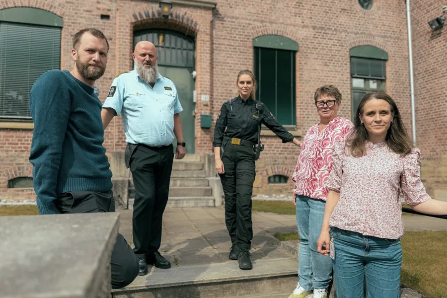 Sykeuhsterapeuter og fengselsansatte foran fengslet, gruppebilde