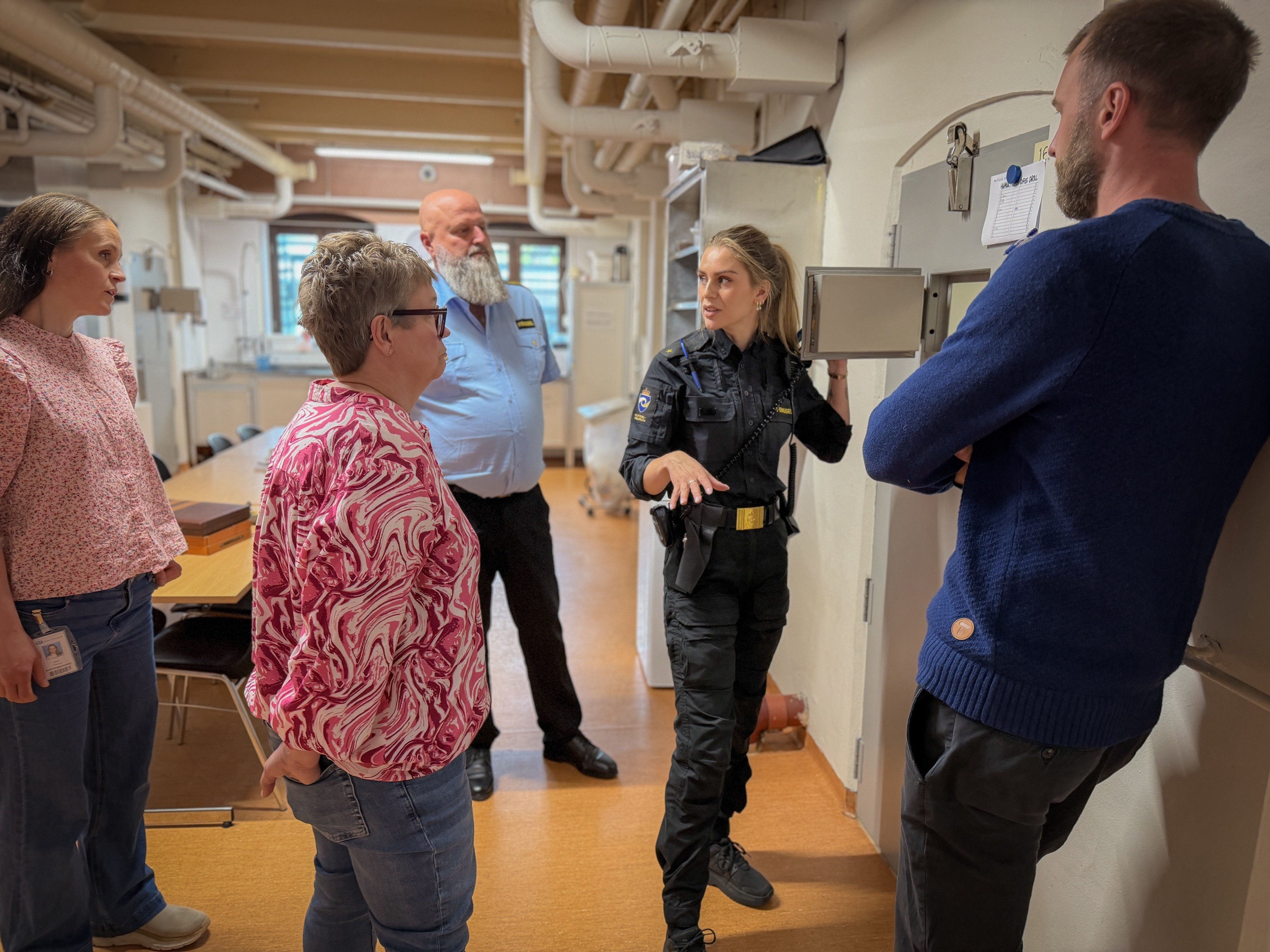 Sykehusansatte terapeuter og fengselsansatte foran en celleluke