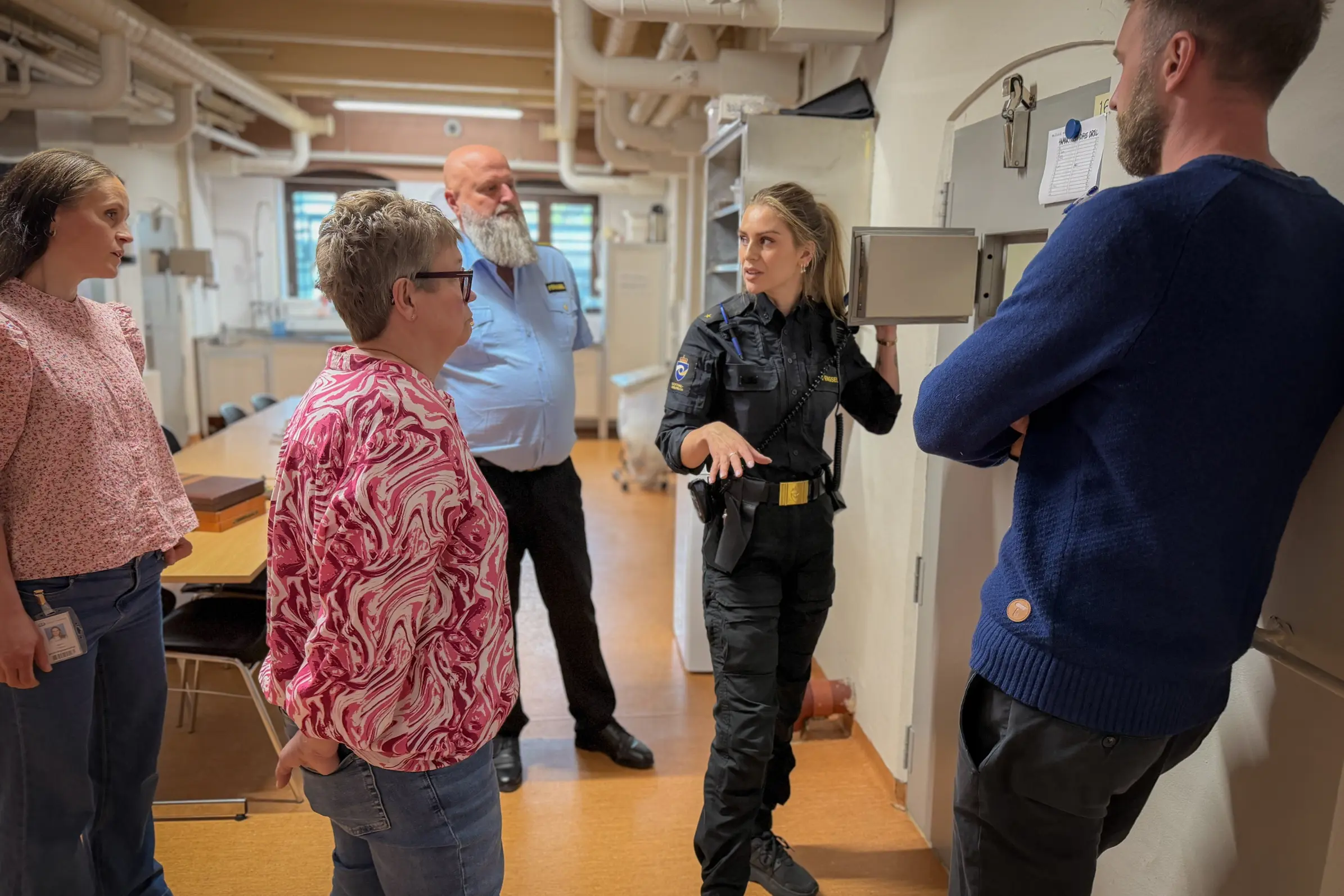 Sykehusansatte terapeuter og fengselsansatte foran en celleluke