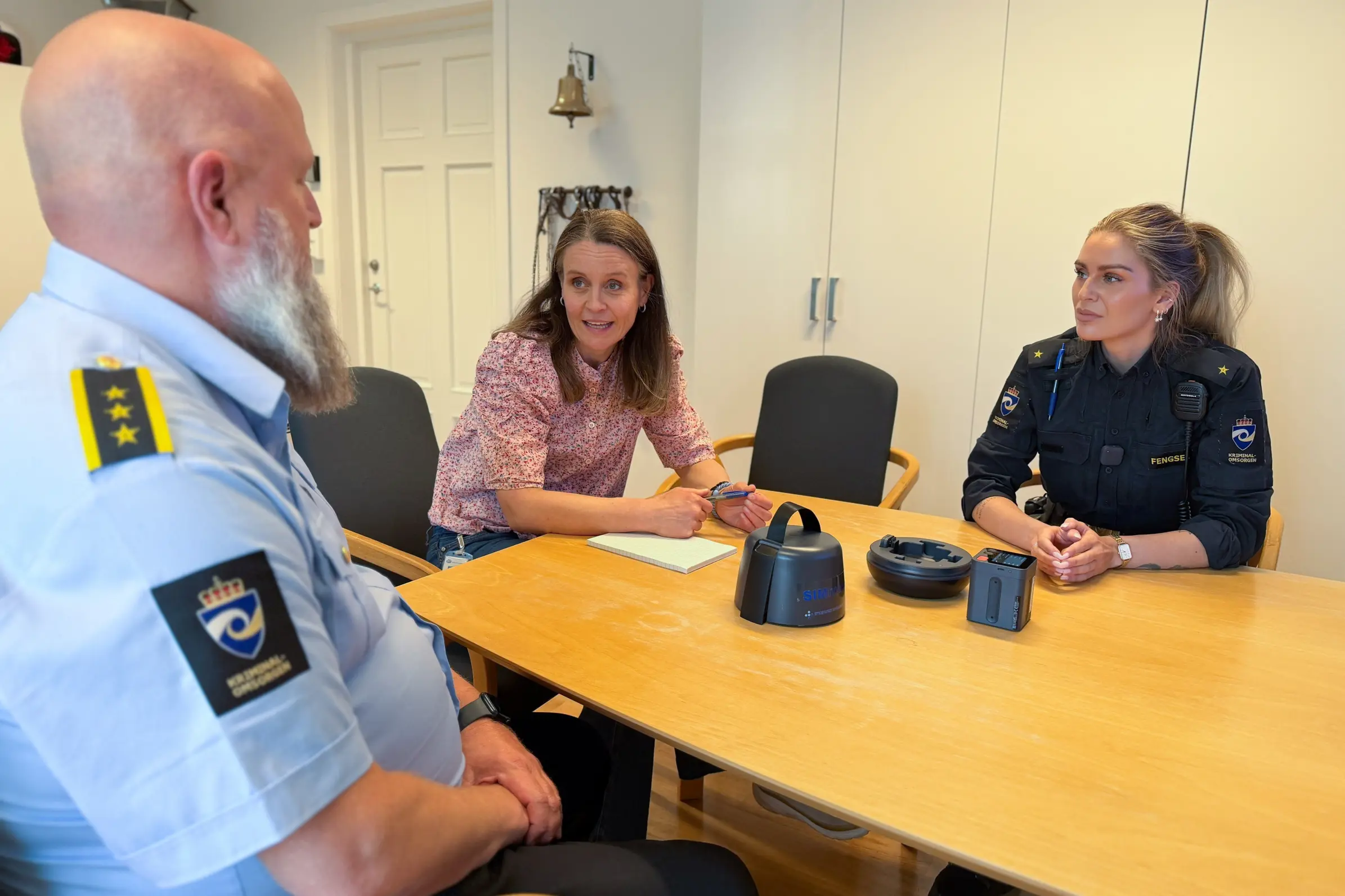 To fengselsbetjenter og programleder for podkasten rundt et bord