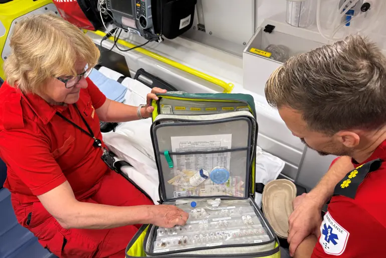 Ambulansearbeider og hospitant går gjennom medikamentveske i ambulanse.