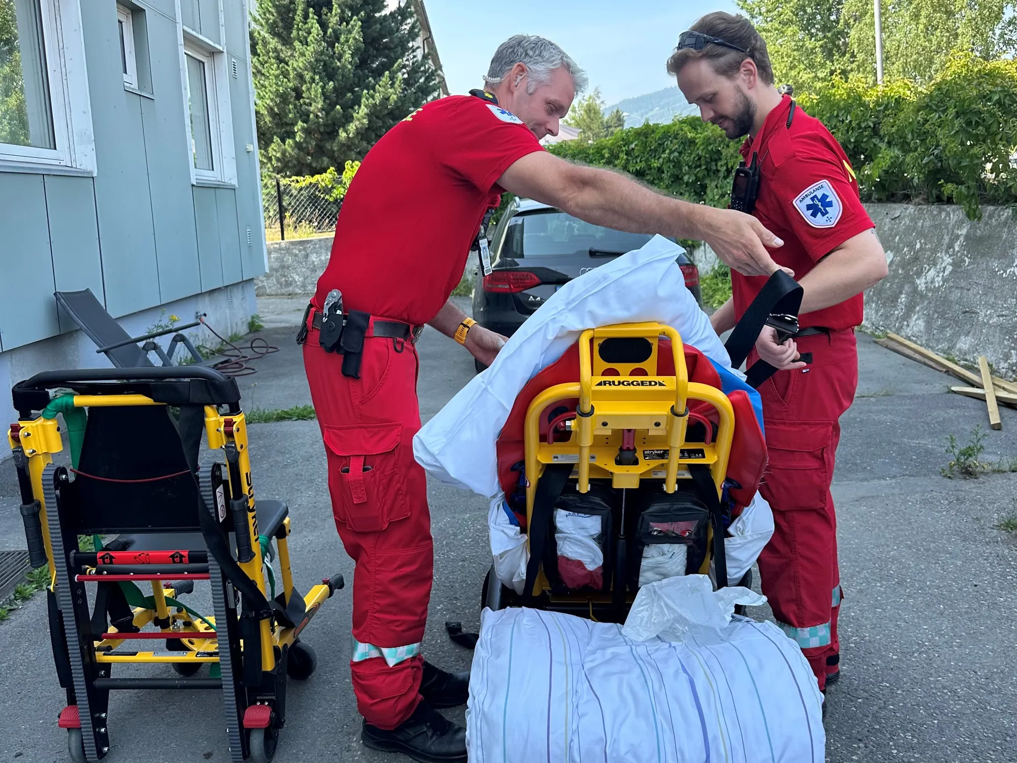 Ambulansepersonell med pasient på båre.