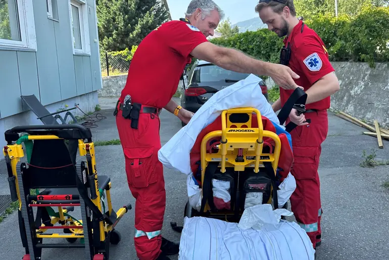 Ambulansepersonell med pasient på båre.