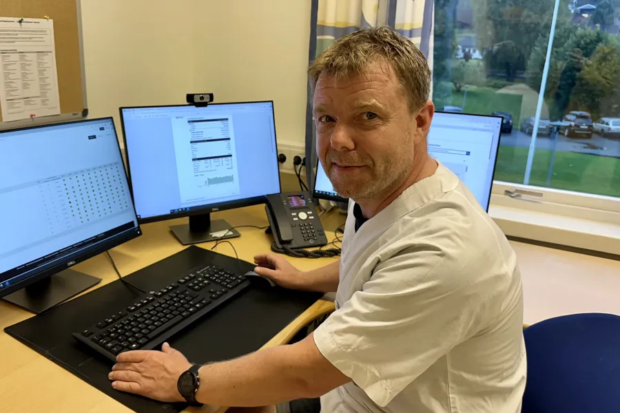 Lungesykepleier Roger Lien sitter ved et skrivebord og bruker løsningen AirView