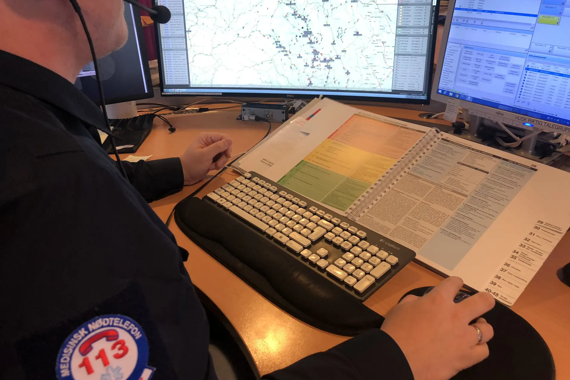 AMK-ansatt sitter i en samtale bak to skjermer