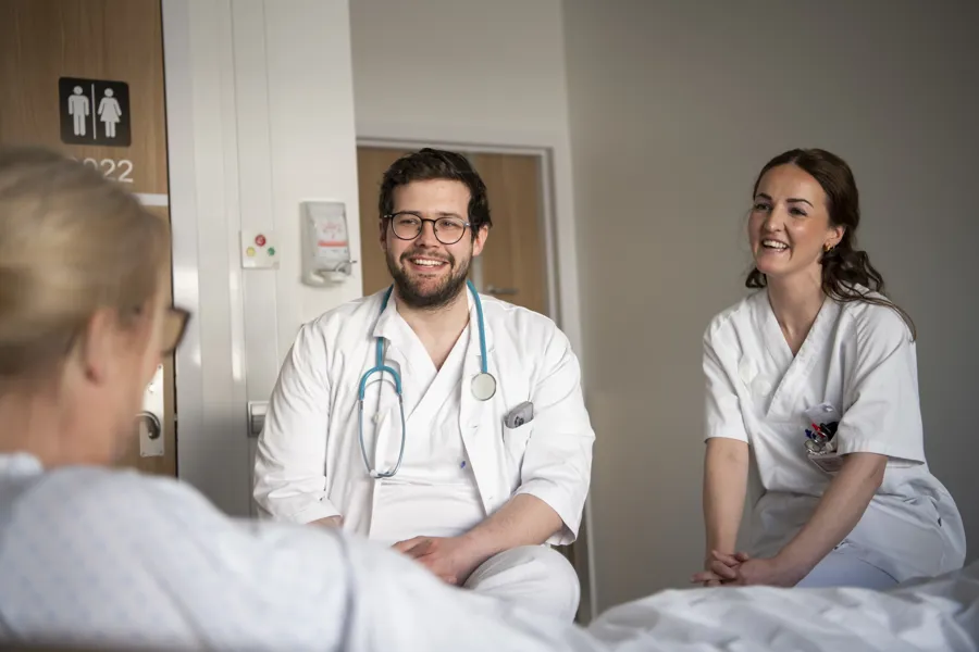 Lege og sykepleier ved pasientseng, illustrasjonsfoto