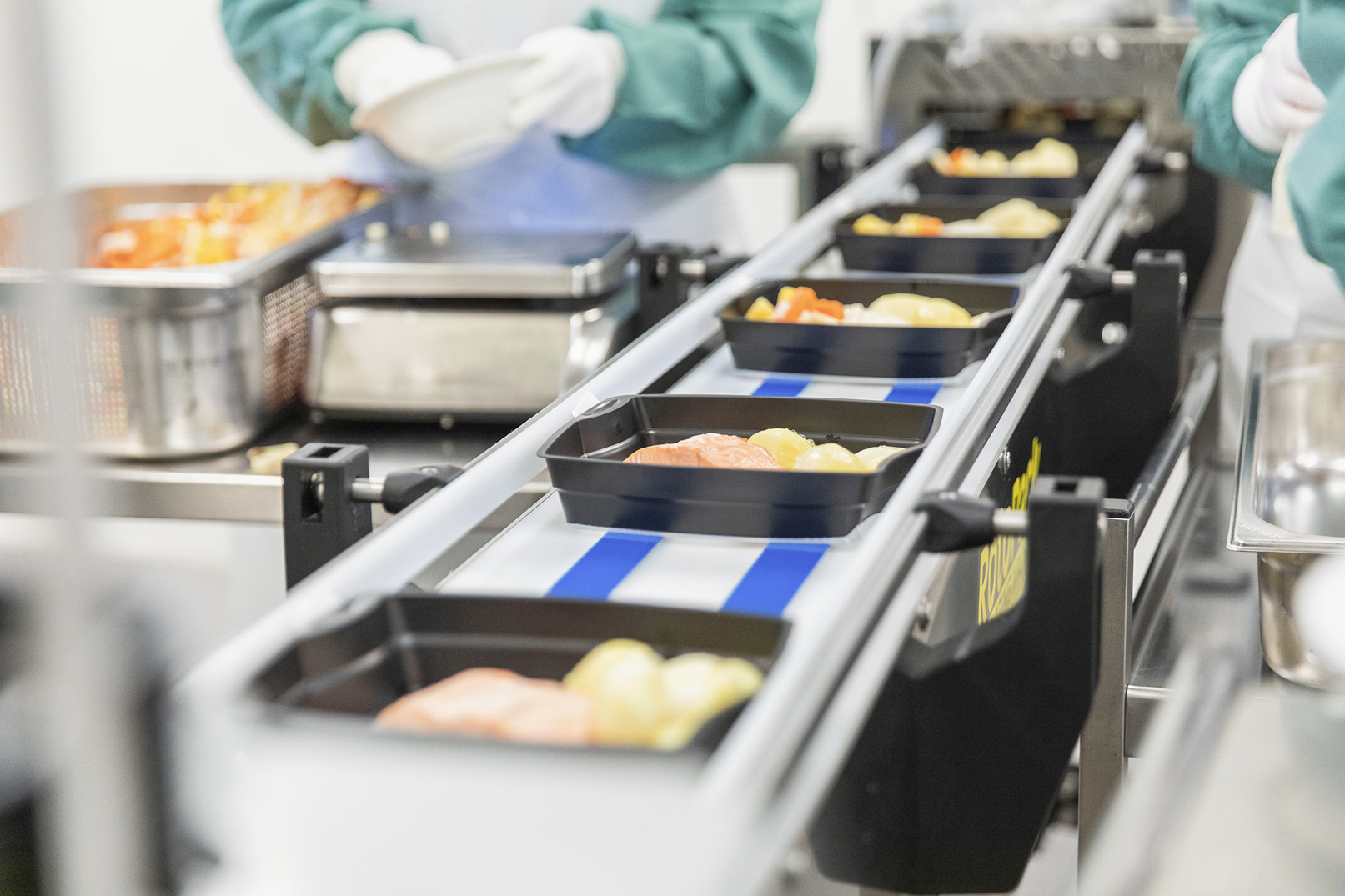 Middagsporsjoner forberedes på produksjonskjøkkenet.