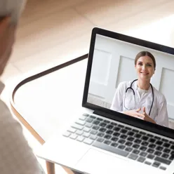 Pasient samhandler med lege via skjerm, illustrasjonsbilde.