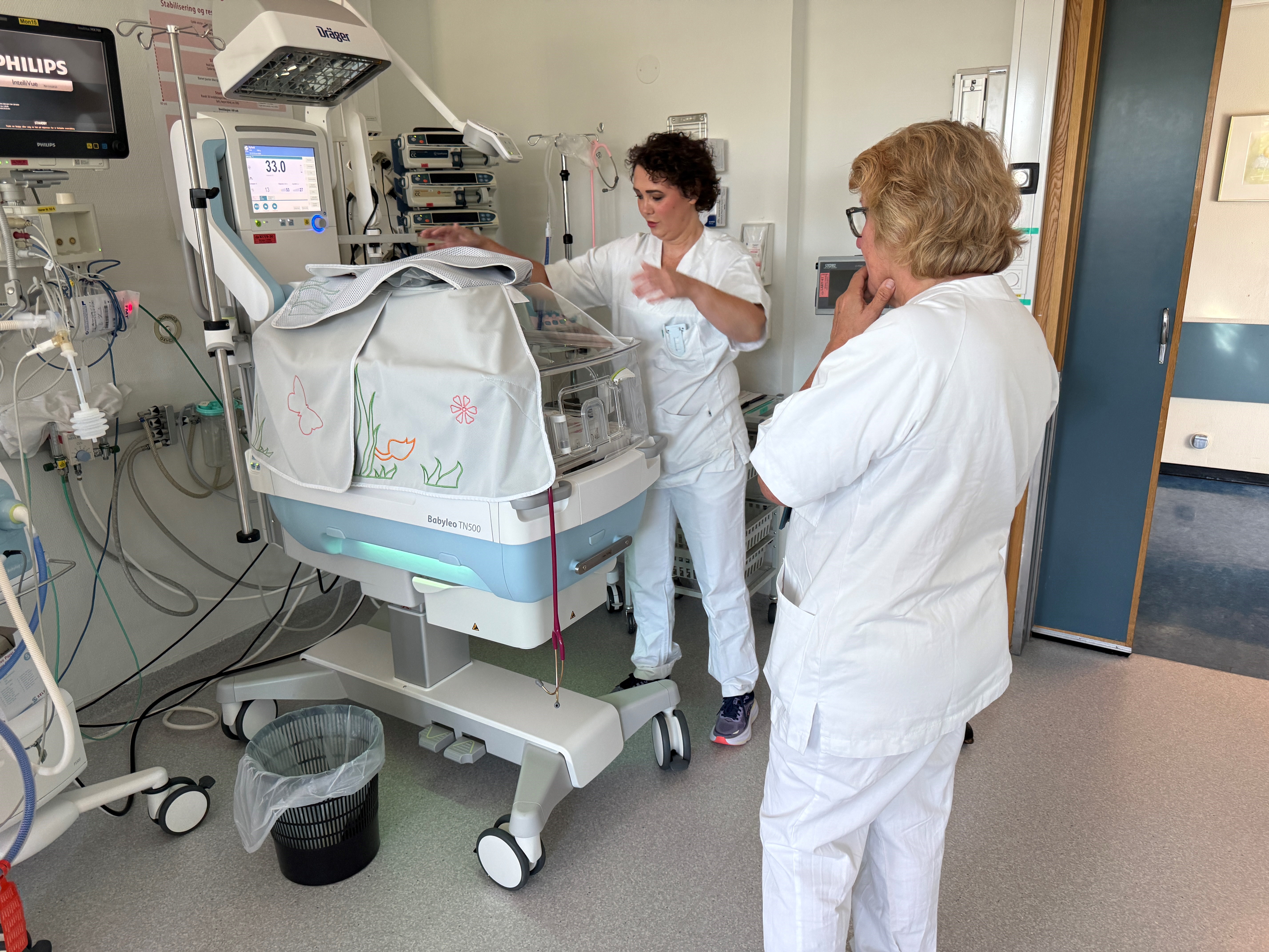 Sykepleier viser fram kuvøse for premature