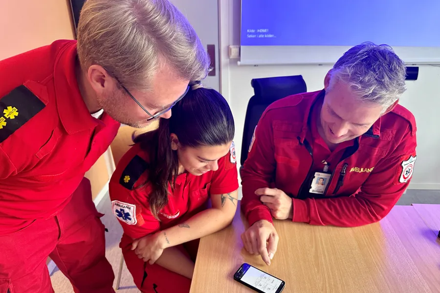 En gruppe mennesker som ser på en mobiltelefon