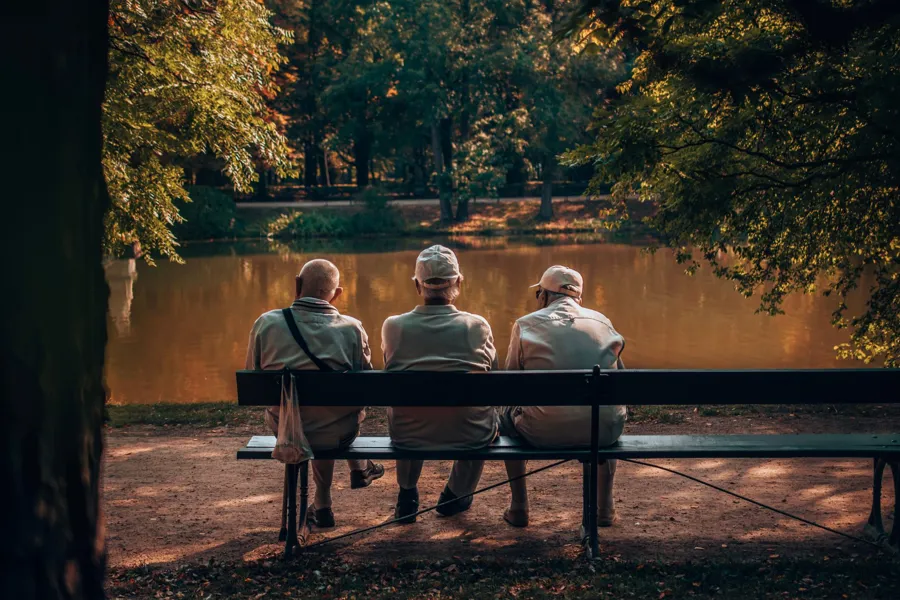 En gruppe gamle menn som sitter på en benk