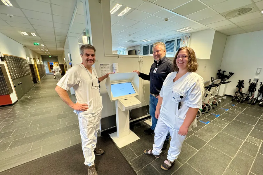 Ansatte i Sykehuset Innlandet viser fram selvbetjeningsautomaten i servicetorget på sykehuset i Lillehammer, grupepbilde