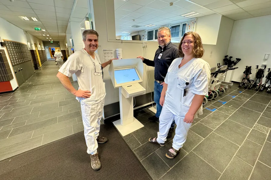 Ansatte i Sykehuset Innlandet viser fram selvbetjeningsautomaten i servicetorget på sykehuset i Lillehammer, grupepbilde
