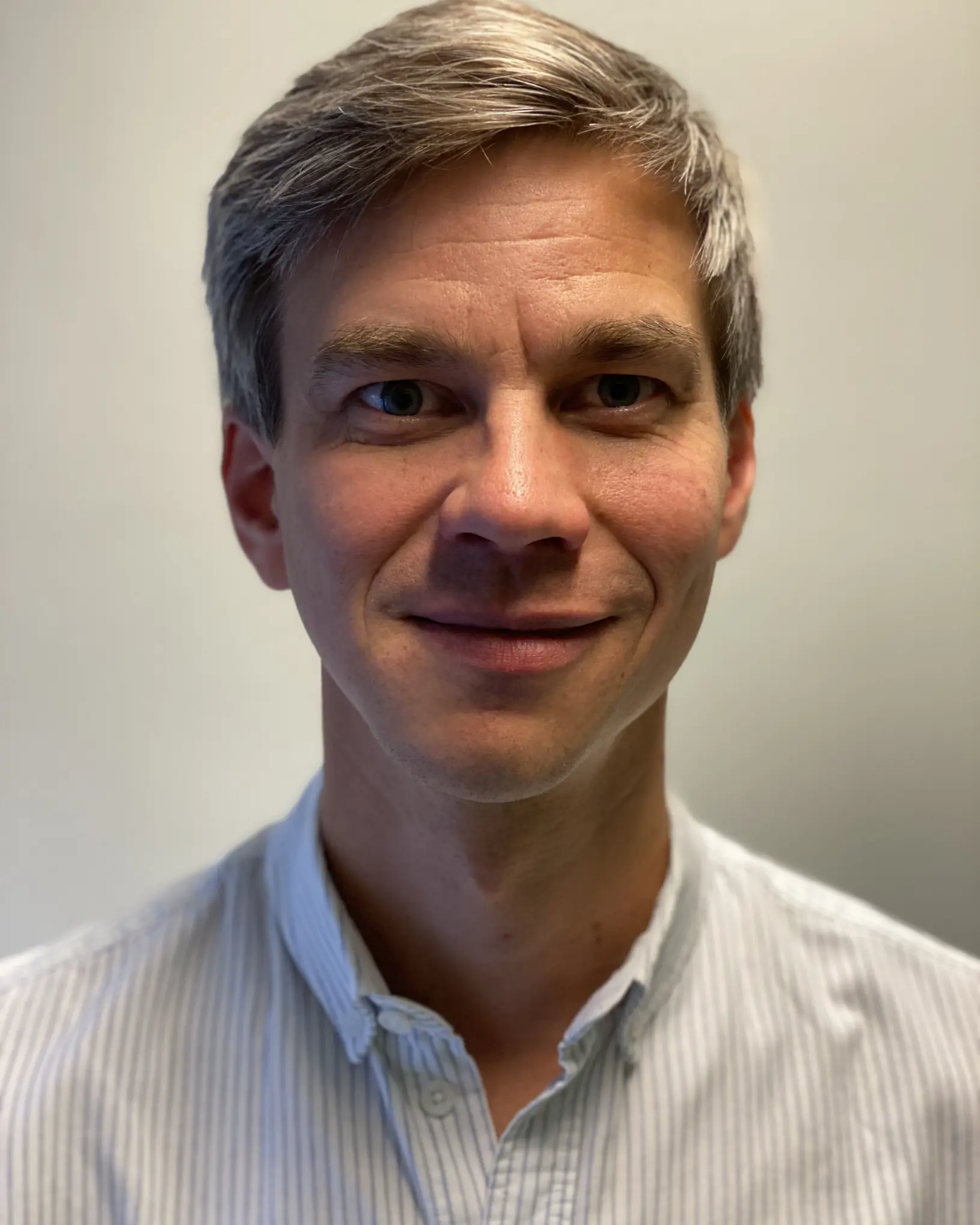 En mann som smiler til kameraet