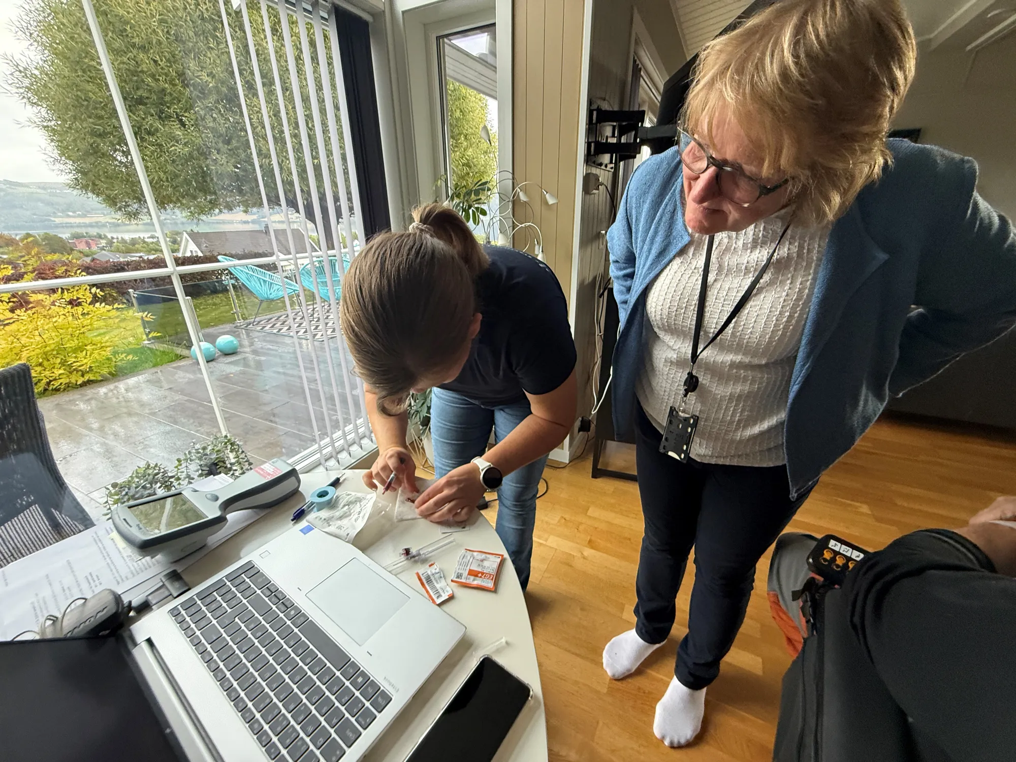 En kvinne som viser en mann noe på laptopen